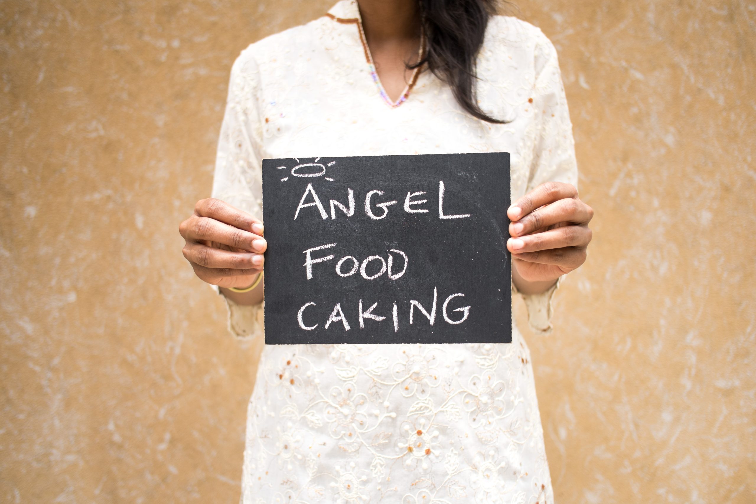 Chalkboard stating Angel Food Caking written in chalk with a halo over the word Angel's first letter
