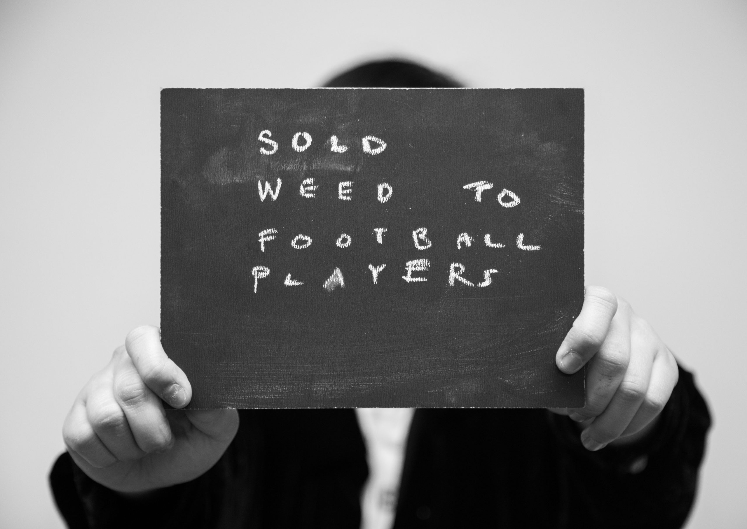 Chalkboard stating Sold Weed to Football Players written in chalk