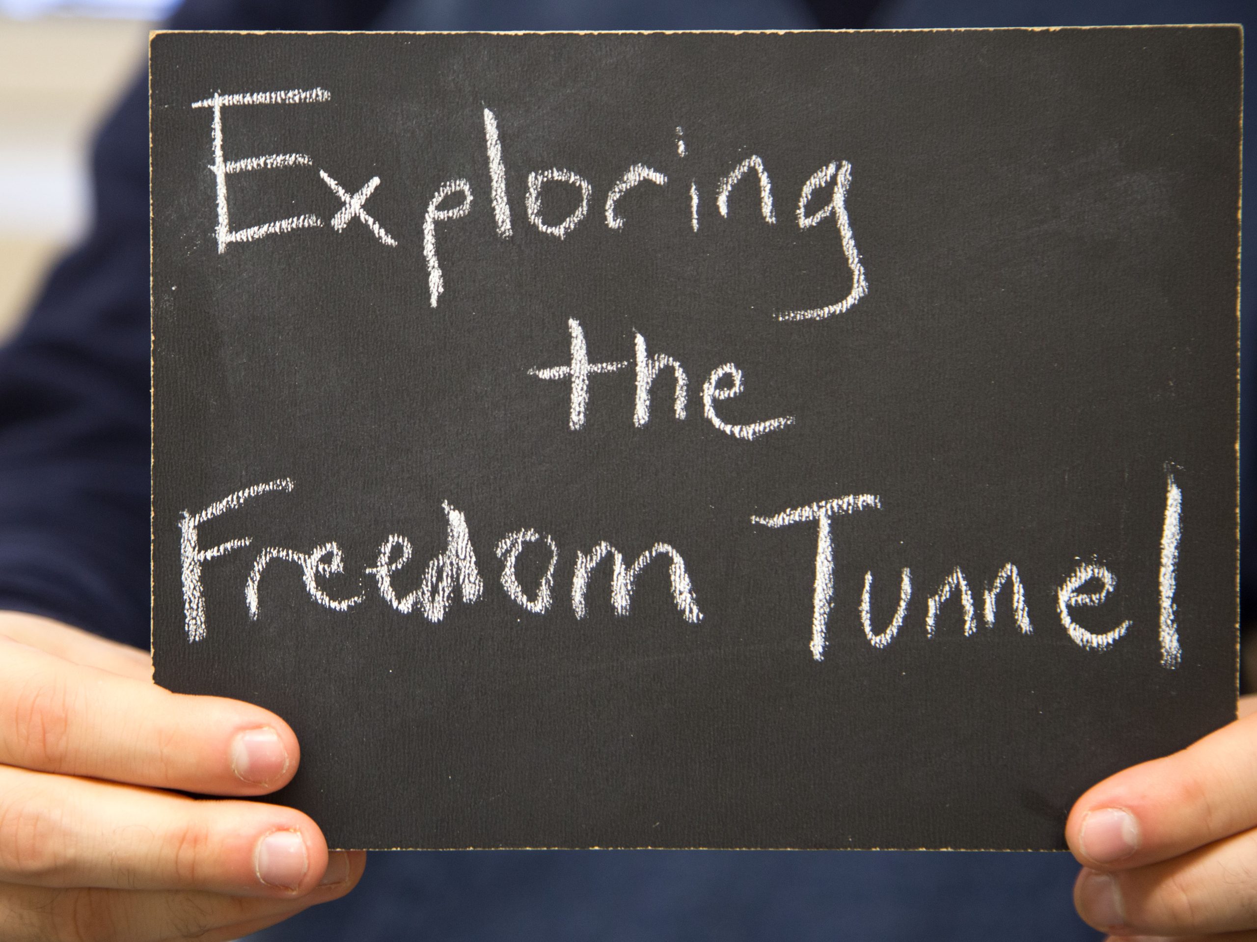 Chalkboard stating Exploring the Freedom Tunnel written in chalk