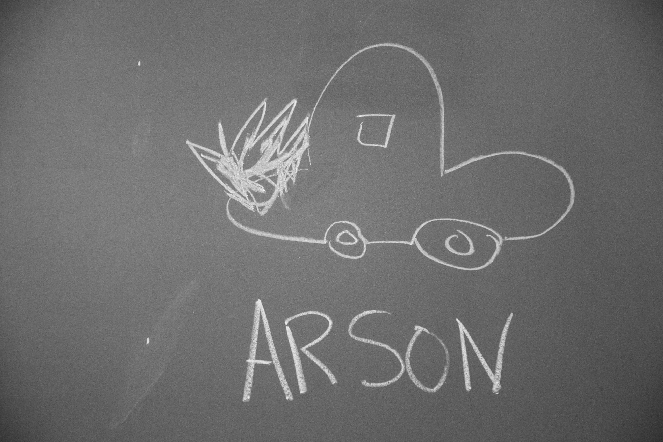 Car on fire with Arson written in chalk