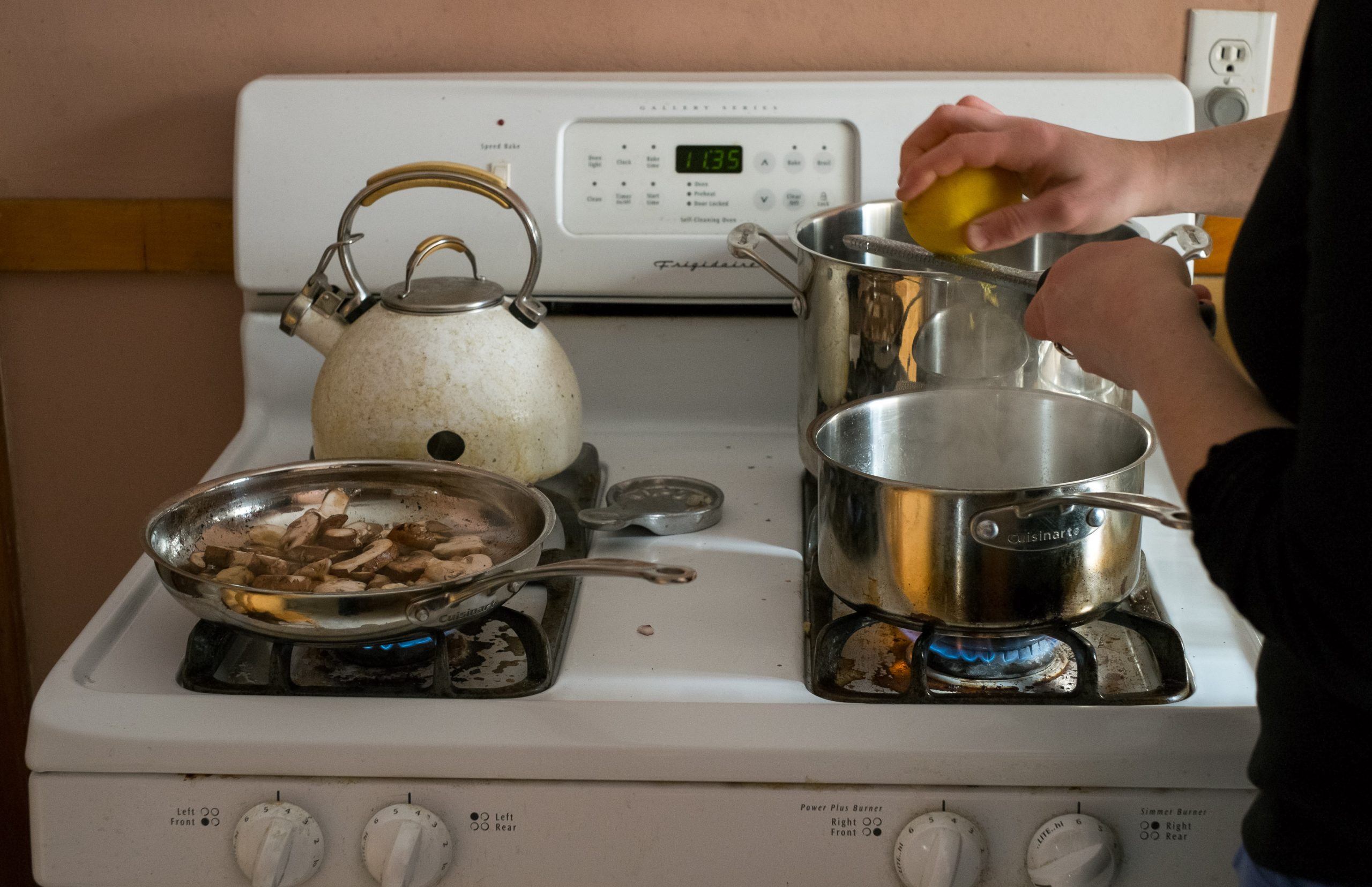 Stovetop with teakettle and three pots and pans