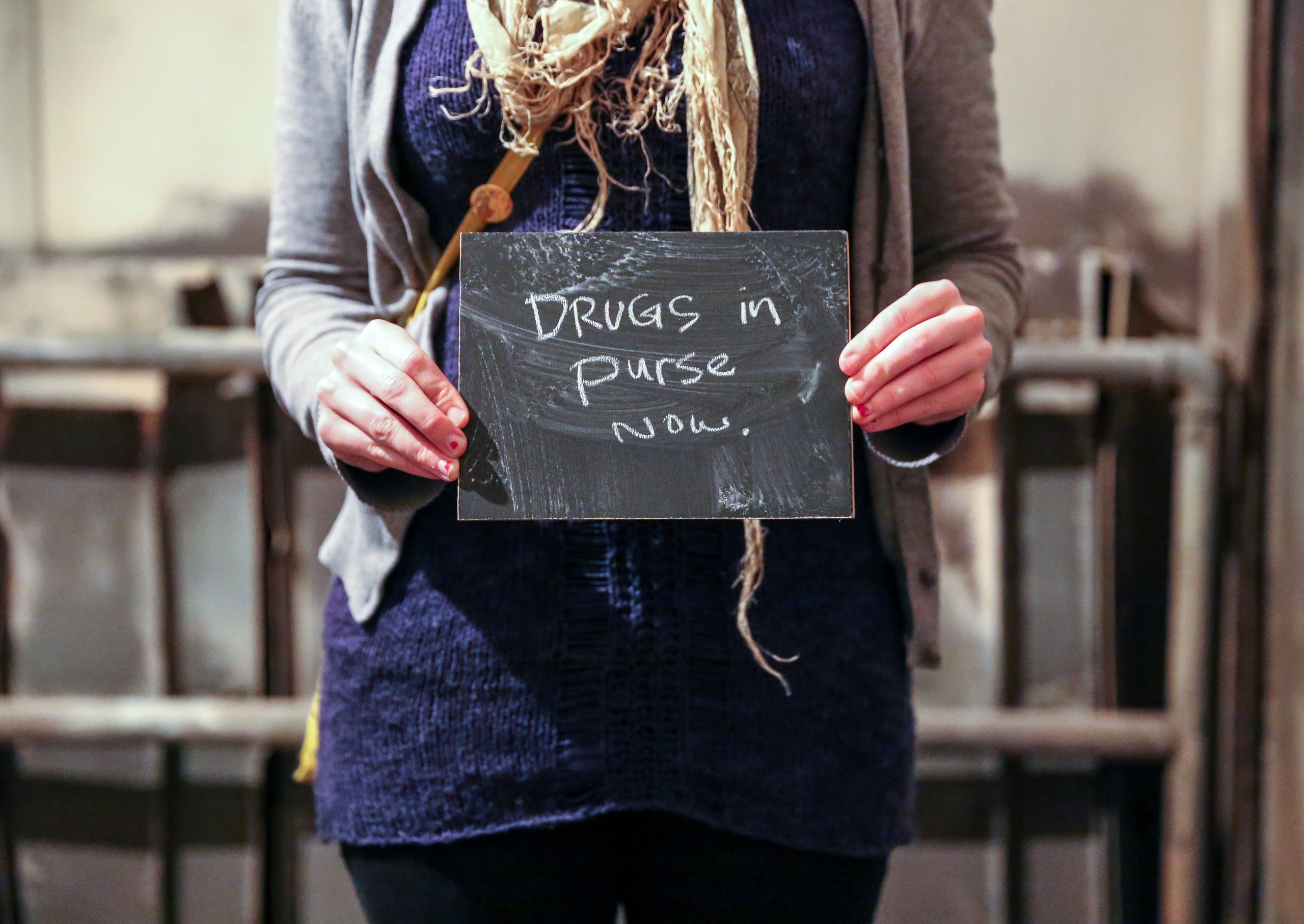 Chalkboard stating Drugs in purse now written in chalk