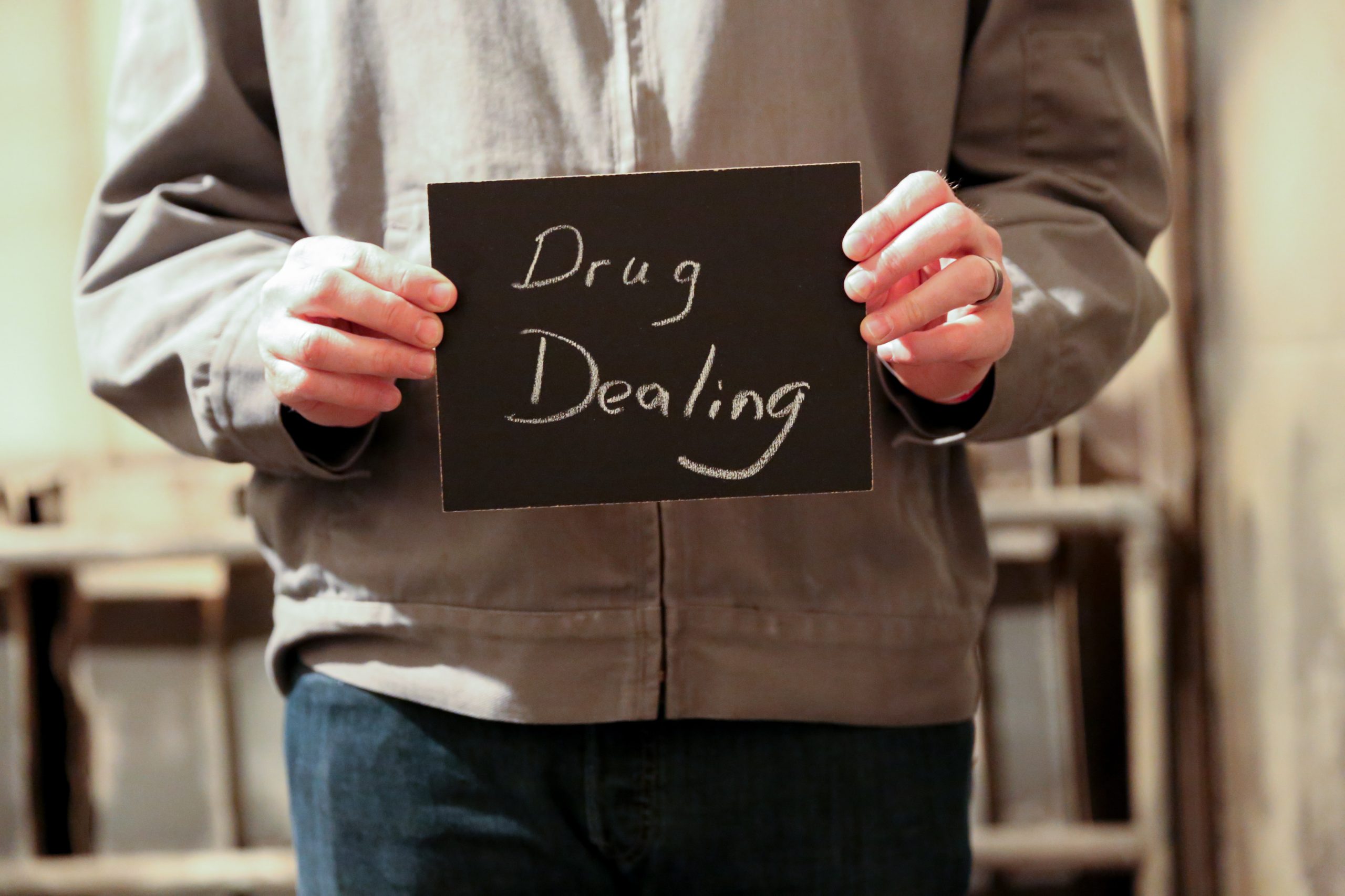 Chalkboard stating drug dealing written in chalk Revolver Chalkboard stating drug dealing written in chalk