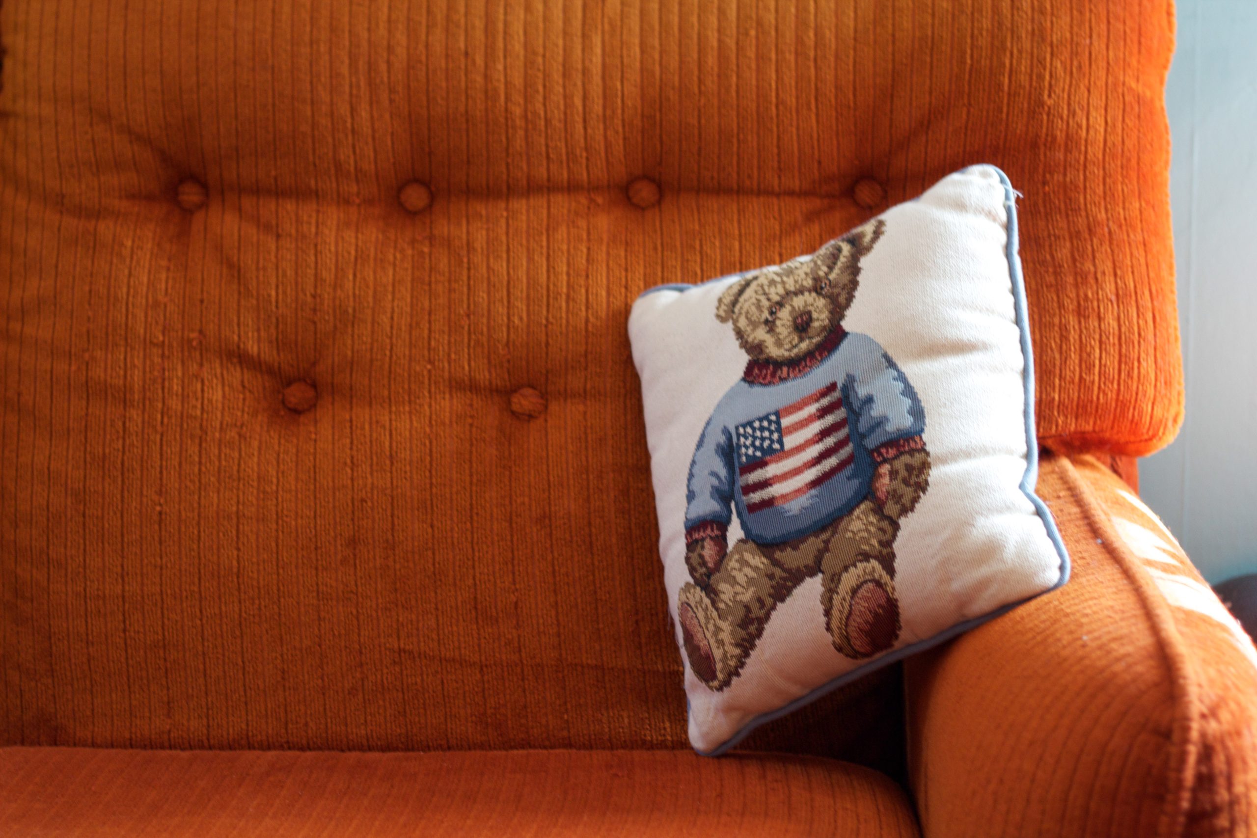 Bear pillow on orange chair