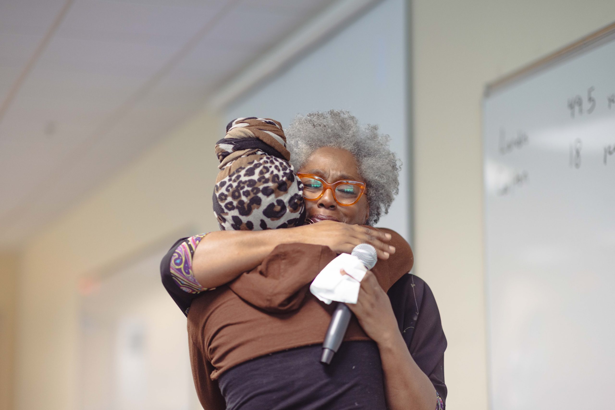 Two Black women embracing at We Resolve event