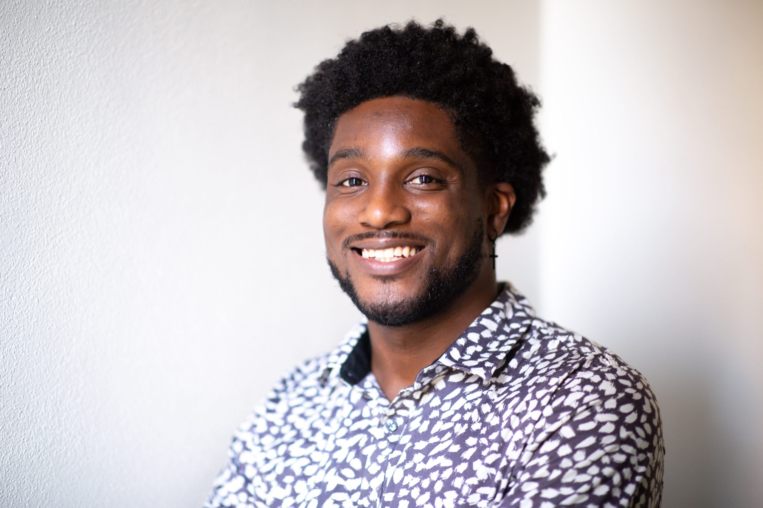 Kahlee and daughter in front of Kahlee's portrait in the Hennepin Theatre Trusts' sidewalk exhibit. She is taking a selfie and looking toward the sun