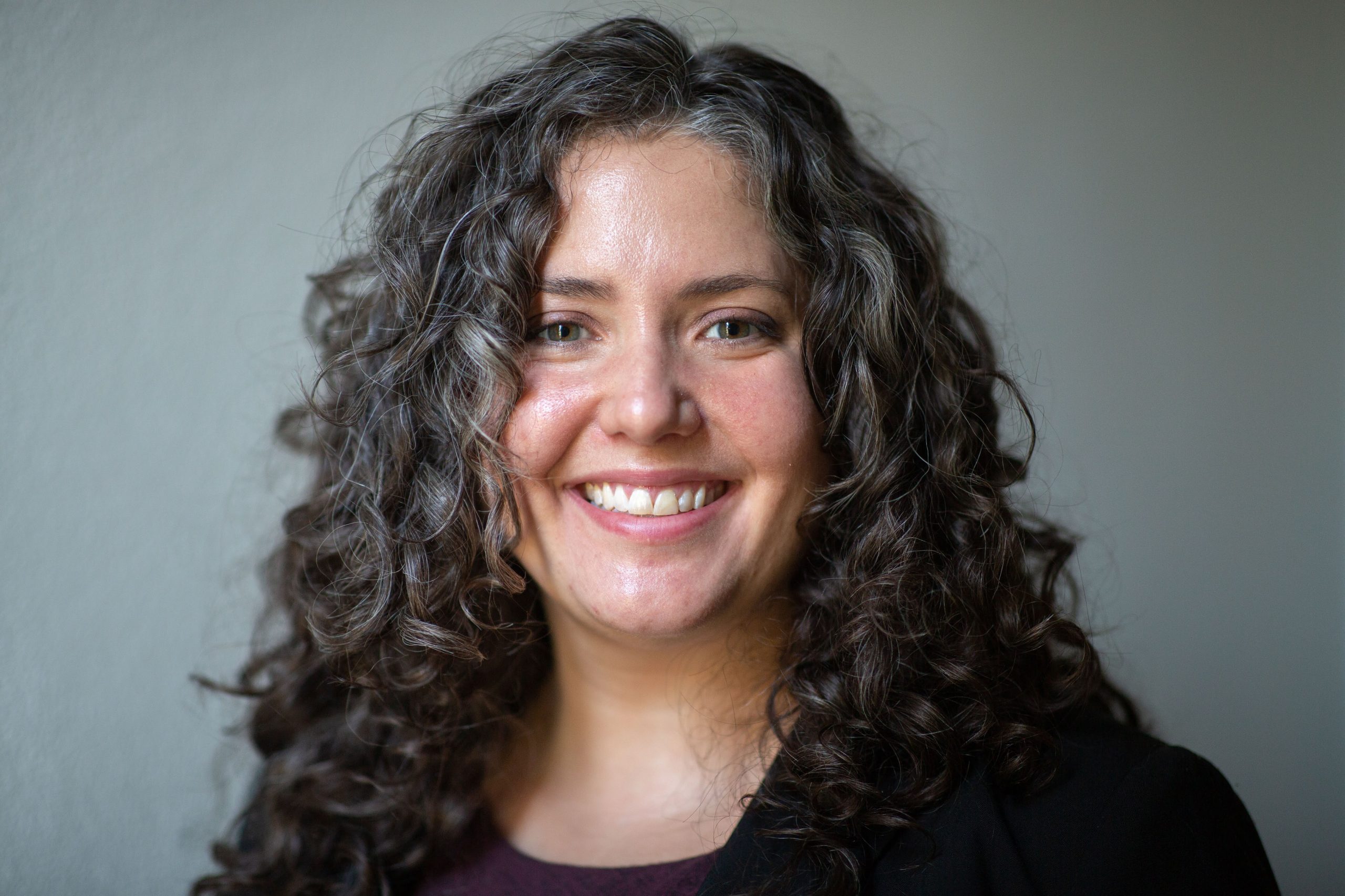 Kevin Reese seated on a red bench in a warehouse, looking directly at camera