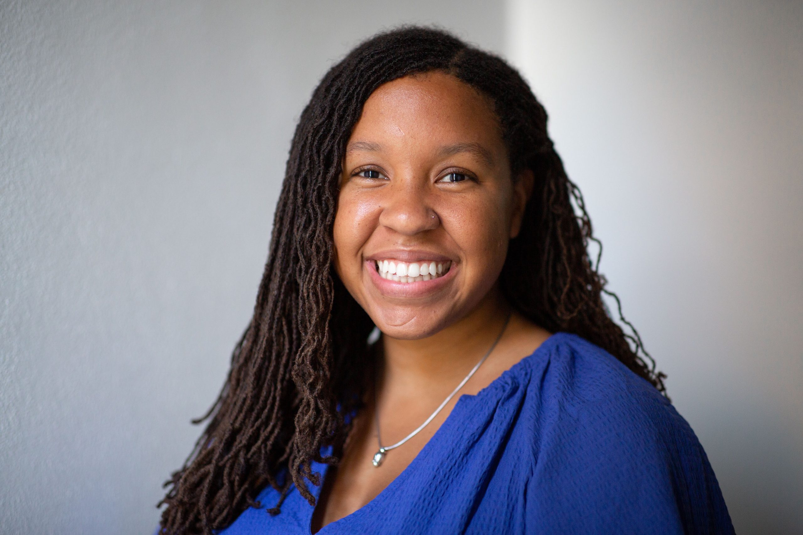 Three people in Until We Are All Free Hoodies smiling and looking directly at camera. It's a sunny, chilly day.