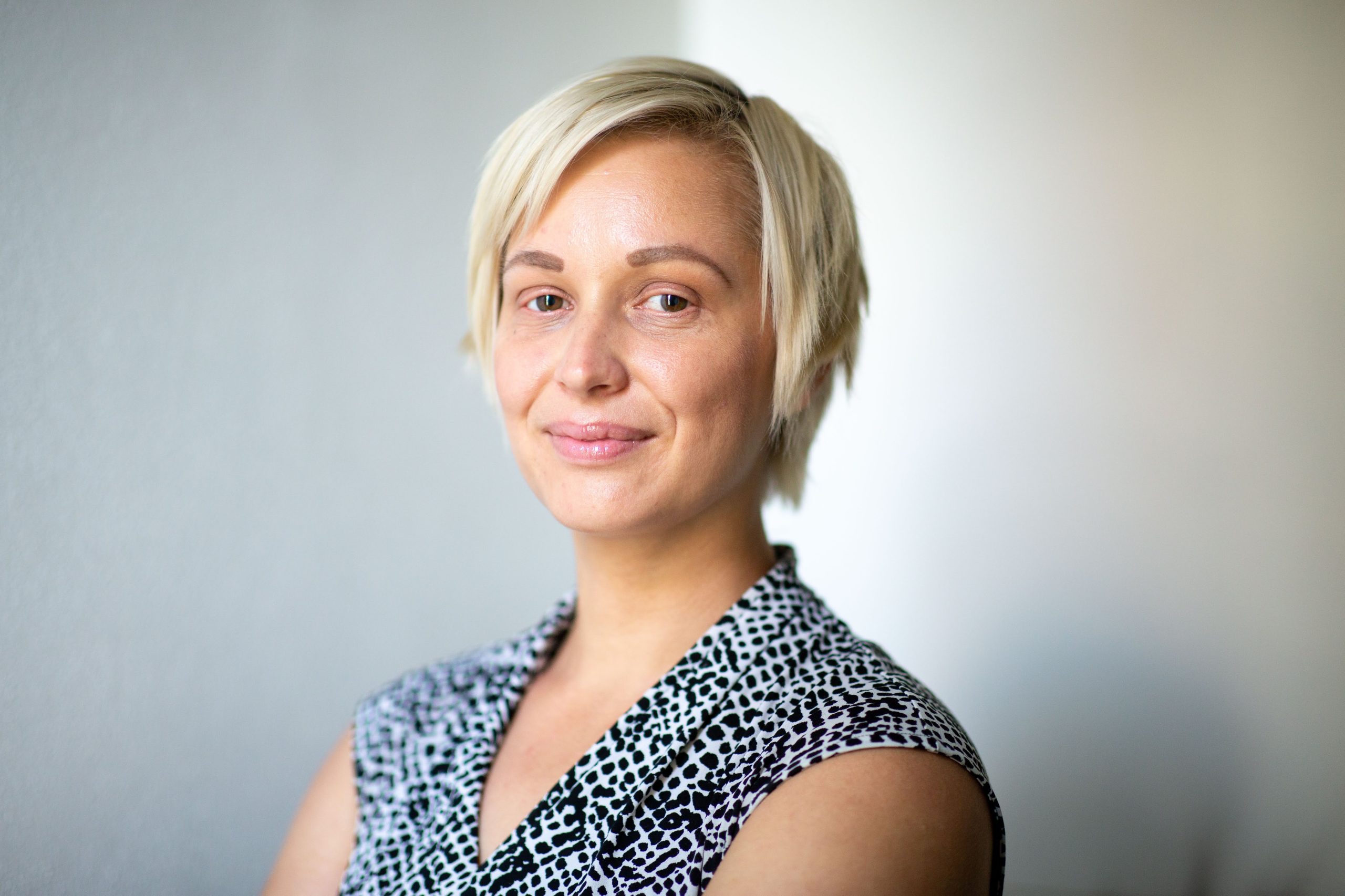 Two people in Until We Are All Free shirts, standing in warehouse, looking directly at camera